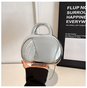 Close-up of the silver mirror acrylic shell bag with metallic chain and zipper detail