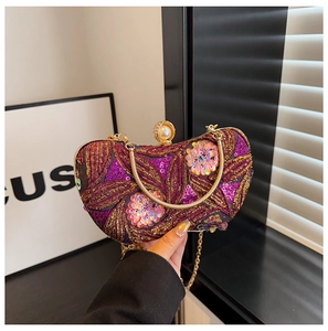 Close-up of purple and gold sequin floral embroidery and pearl clasp on evening bag