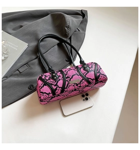 Chic pink and black snake print bowler bag with black handles and metal nameplate detail