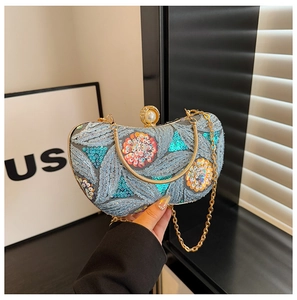 Detailed close-up of light blue sequined evening bag with leaf embroidery and pearl clasp
