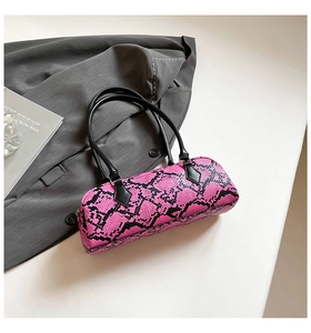 Close-up of pink snake skin pattern cylinder handbag with black leather handles