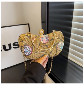 Detail of sequin embroidery evening clutch with pearl clasp and gold chain strap