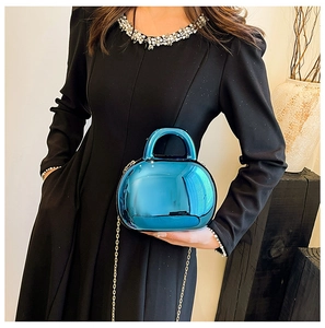 Detail of glossy blue acrylic shell bag with metallic reflection and gold chain strap