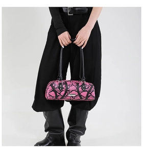 Detailed macro of pink snake skin texture and silver rivets on the boston bag