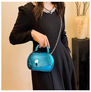 Blue shell bag with chrome metallic finish and gold chain strap shown on black dress
