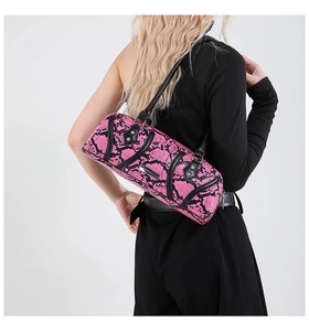 Detail view of pink snakeskin barrel bag with silver logo plate on a black strap