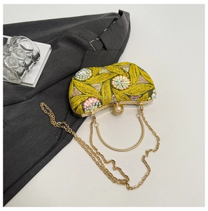 Detail of yellow sequin evening bag with floral embroidery, ring handle and pearl clasp