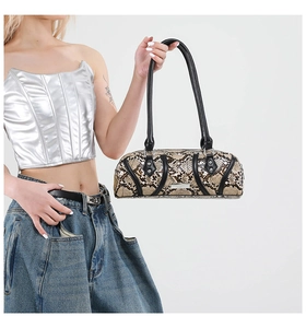 Close-up of retro snakeskin pattern cylindrical handbag with silver metal logo plate