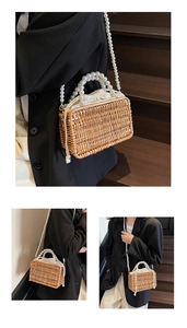 Close-up of a handwoven straw bucket bag with elegant pearl handle and drawstring lining