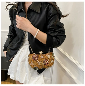 Close-up of golden evening bag with sequins, embroidery and luxury pearl clasp detail