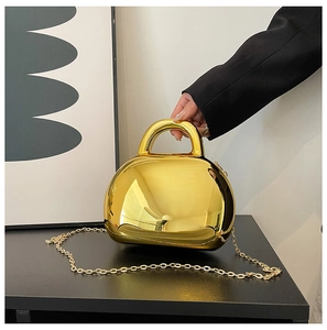 Detailed close-up of a semi-circular gold acrylic shell bag with a sleek metallic finish
