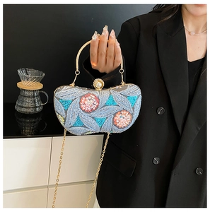 Detail of light blue sequined evening bag with floral embroidery and pearl clasp