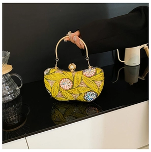 Detail of yellow hand-embroidered evening bag with sequins and pearl clasp