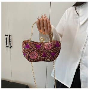 Detail of luxury sequined evening bag with purple flower embroidery and pearl clasp