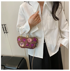 Lifestyle view of purple sequin flower clutch with gold chain and jewelry buckle