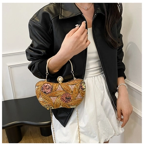 Close-up of floral sequin evening bag with large pearl clasp and golden chain strap