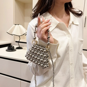 Sac à main élégant en perles argentées avec bandoulière dans un décor intérieur chic