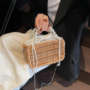 Handwoven straw basket bag with elegant pearl top handles and a drawstring inner pouch