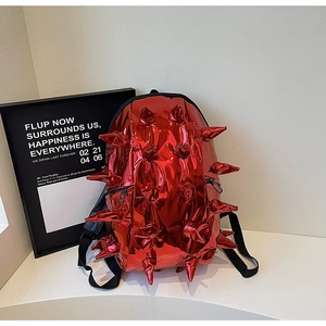 Detail of glossy red patent leather backpack with creative 3D hedgehog spike design