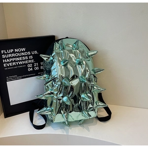 Macro detail of mint green metallic punk backpack with creative 3D conical spikes