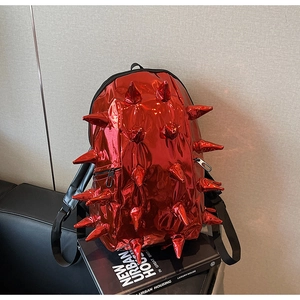 Macro detail of red metallic backpack featuring 3D spikes and black zipper accents