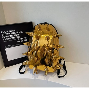 Macro view of gold spiked backpack with metallic finish and black adjustable straps