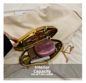 Internal capacity of gold acrylic evening bag showing phone, wallet and lipstick