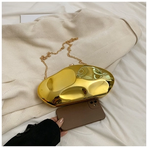 Detail of gold fluid acrylic clutch with metal chain showing size next to a phone