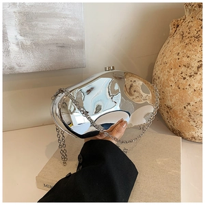 Detail of silver mirror acrylic evening bag with metallic chain and fluid design