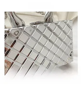 Detail view of silver quilted box clutch featuring metallic mirror finish and chain strap
