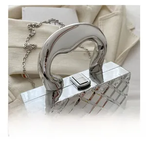 Close-up of a silver chrome handbag with geometric texture and metal chain strap