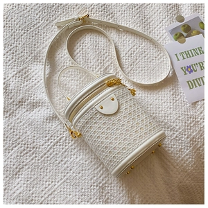 Detail of white woven cylinder bag with iridescent sequins and protective metal base studs