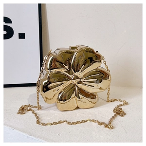 Detail shot of the 3D gold flower-shaped clutch bag with polished finish and metal chain