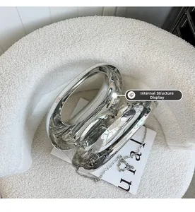 Sac à main argenté métallisé sur chaise en polaire blanche avec détails de la chaîne