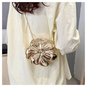 Detailed view of the gold flower-shaped hard shell box bag with metallic chain strap