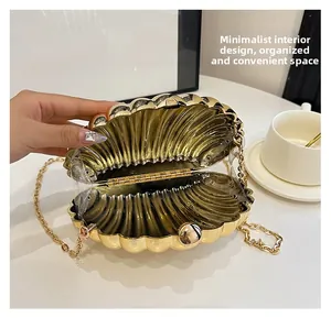 Detail view of gold shell evening bag showing spacious interior design and chain strap