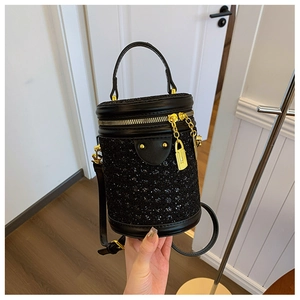 Detailed view of black glitter cylinder bag with gold hardware and padlock decoration