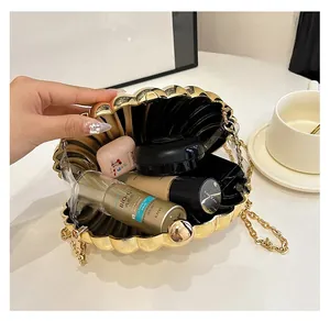 Detailed view of golden shell evening clutch interior with cosmetics and chain strap