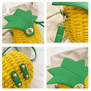 Detail view of handmade pineapple woven crossbody bag with green leaf top and gold hardware