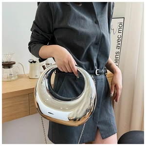 Détail d'un sac à main croissant argenté avec finition miroir et chaîne en métal