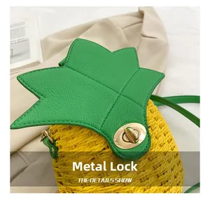 Detail of the golden metal swivel lock and woven straw texture on the pineapple bag