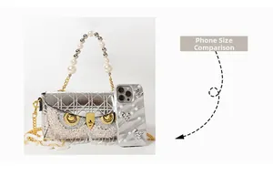 Silver owl shoulder bag with rhinestones and tassel next to a phone for size comparison