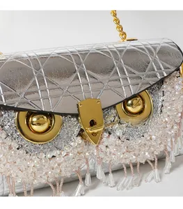 Close-up of silver quilted handbag featuring unique eye clasp and crystal bead fringe