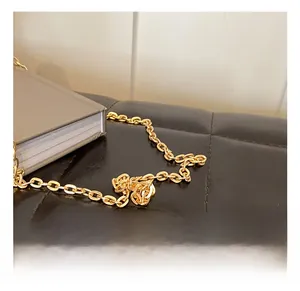 Detailed close-up of golden metallic chain strap and hardware on an acrylic clutch bag