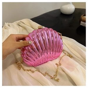 Dettaglio della pochette a conchiglia rosa metallizzato con catena d'oro e chiusura