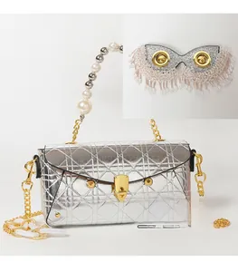Detail of silver quilted bag with pearl handle, chain strap and sequin tassel mask charm