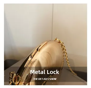 Macro detail of glossy golden acrylic clutch showing metal lock and chain strap