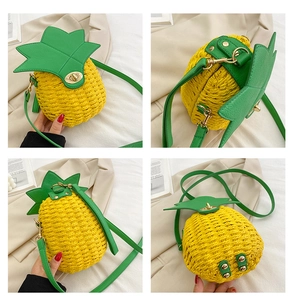 Detail view showing pineapple straw bag with green leaf flap and golden swivel lock