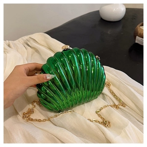 Dettaglio della pochette lucida a forma di conchiglia verde con catena dorata