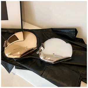 Close-up of pebble-shaped acrylic clutch bags with metallic gold and silver finish